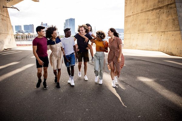 United group of multiracial young friends walking on city street - Millennial diverse best friends enjoying free time together in summer holidays